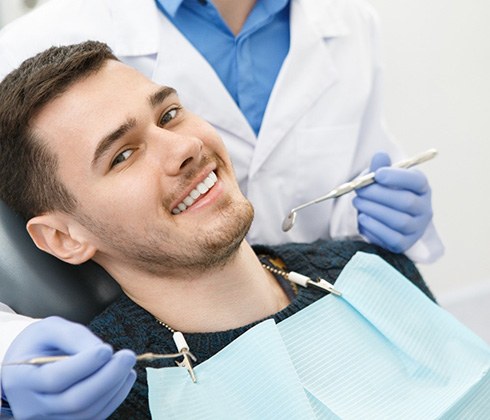 Happy female dental patient making OK sign with her hand