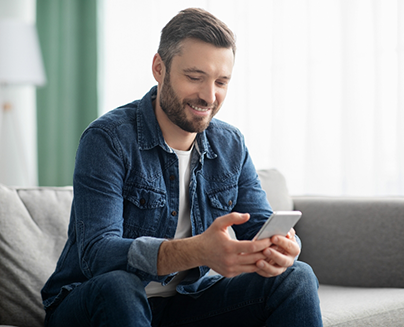 Man sitting on couch looking at phone