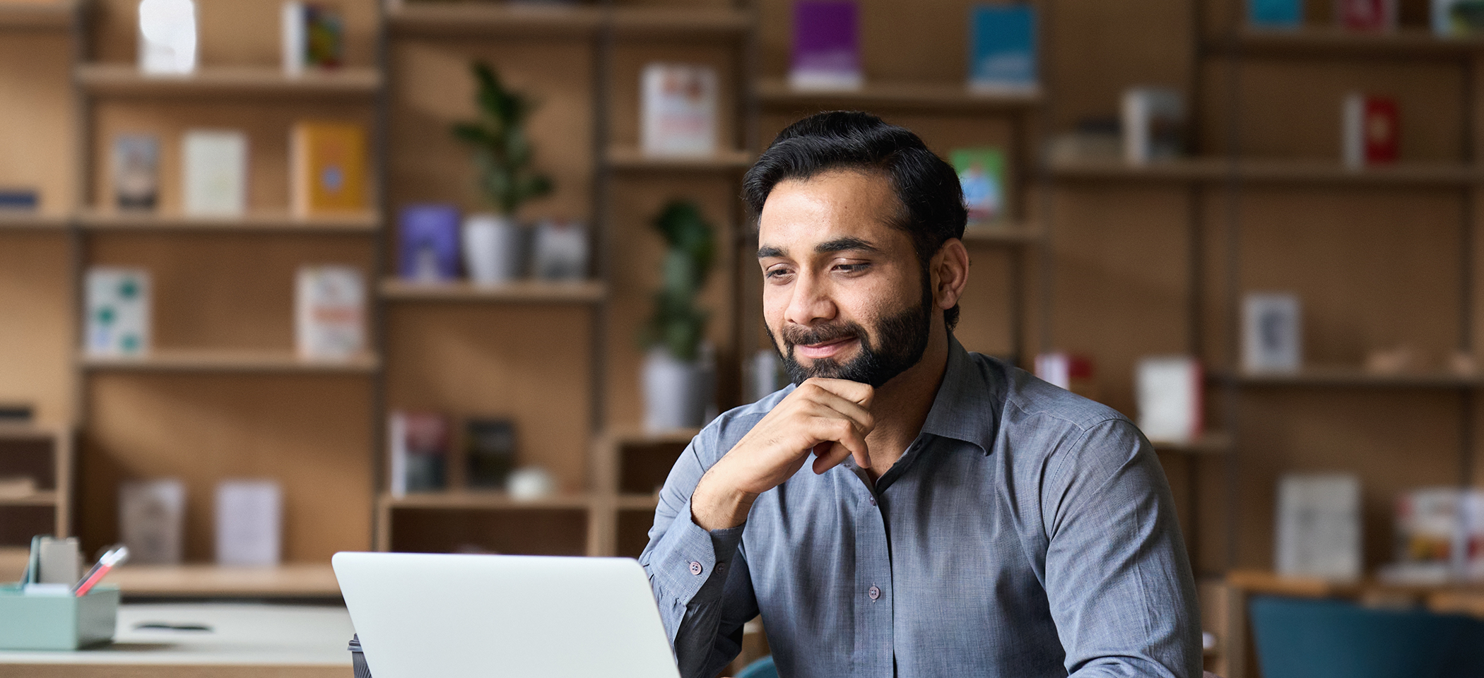 Man smiling while looking at his laptop