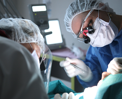 Dentist with mask performing wisdom tooth extraction